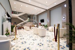 a lobby with white chairs and a staircase at Hotel del Sole in Pompei