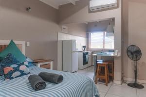 een slaapkamer met een bed met kussens en een keuken bij Pelicans Pad @ St Lucia in St Lucia