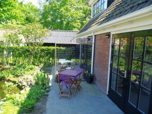 un patio con mesa púrpura y sillas en 't Laaisterplakky, en Oude Bildtzijl