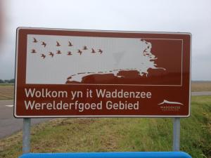 a sign on the side of a road with a flock of birds at 't Laaisterplakky in Oude Bildtzijl