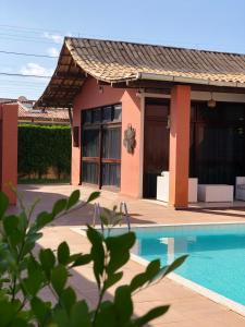 una casa con piscina frente a ella en Casa de Praia Orla de Atalaia Casa da Fabi, en Aracaju