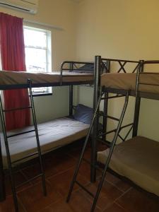 a room with three bunk beds and a window at Travel Lodge Sabie in Sabie