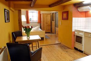 een keuken met gele muren en een tafel en stoelen bij Ferienwohnung Im Damm in Quedlinburg