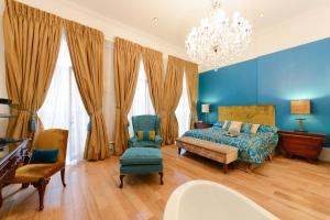 Dormitorio azul con cama y lámpara de araña en Twenty Nevern Square Hotel, en Londres