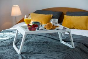 ein weißes Tablett mit Essen und Getränken auf einem Bett in der Unterkunft Królowa Śniegu in Karpacz