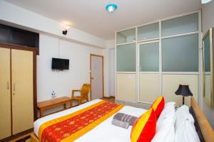 a bedroom with a large bed and a tv at The Boudha Inn in Kathmandu