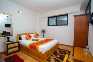 a bedroom with a bed and a window at The Boudha Inn in Kathmandu