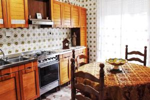 a kitchen with a table and a stove and a sink at Umberto I - Affitti brevi in Favara