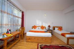 a hotel room with two beds and a window at The Boudha Inn in Kathmandu