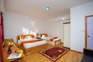 a hotel room with two beds and a table at The Boudha Inn in Kathmandu