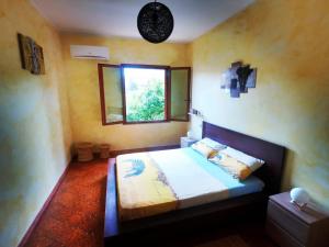 1 dormitorio con cama y ventana. en Lune d'Africa, en Furtei