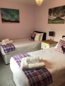 1 dormitorio con 2 camas y mesa con lámpara en Glenlochy Nevis Bridge Apartments, en Fort William