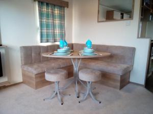 einen Esstisch mit zwei blauen Kerzen oben in der Unterkunft Premium Accomodation with Hot Tub, Tattershall Lakes Country Park in Tattershall + 5 Fotos