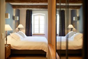 a bedroom with two beds and a mirror at Les Chambres de l'Oustalet in Gigondas