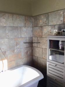 uma banheira na casa de banho com uma parede de pedra em Les Outres em Chabrac
