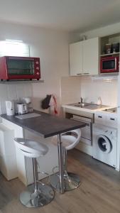 a kitchen with a table and two bar stools at Appartement Capbreton / Hossegor in Capbreton