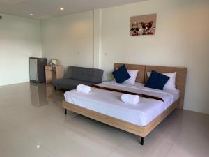 1 dormitorio con 1 cama grande y 1 silla en Khao Oat airport en Nai Yang Beach