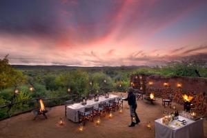 a person standing in front of a table with candles at Madikwe Safari Lodge in Madikwe Game Reserve +121 photos