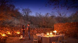 a man and woman standing in front of a table with lights at Madikwe Safari Lodge in Madikwe Game Reserve +67 photos