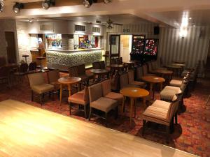 a restaurant with a bar with tables and chairs at Silversands Hotel in Blackpool