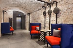 Habitación con sillas azules y pared de ladrillo en Ribas Rooms Ferenc Lviv, en Leópolis