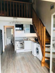 une cuisine avec des placards blancs et un escalier dans l'établissement Appartement - Résidence Le Paradou, à Rayol-Canadel-sur-Mer