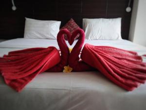 Dos cisnes se ven como si se estuvieran besando en una cama. en Nuriani Rooms, en Ubud