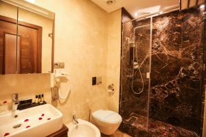 een badkamer met een douche, een wastafel en een toilet bij Suite Hotel Casa Diamond in Casablanca