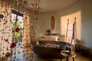a bath tub in a room with a window at Marataba Safari Lodge in Hartbeestfontein