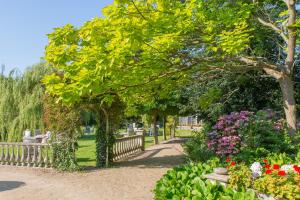 un parque con un banco y flores y árboles en Hotel Pension 't Huys Grol en Renesse