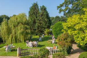 a group of people sitting at tables in a park at Hotel Pension 't Huys Grol in Renesse