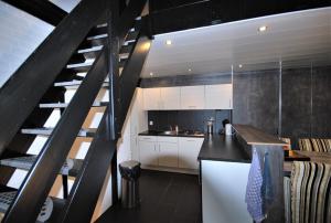 una cocina con una escalera que conduce a un loft en Bungalows Bospark te Stramproy, en Stramproy