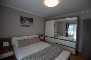 een slaapkamer met een bed en een grote spiegel bij Apartament Saguna in Sînnicolau Mare