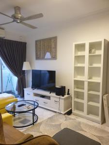 a living room with a flat screen tv and a table at 5-Bedroom Family Apartment in Seri Kembangan