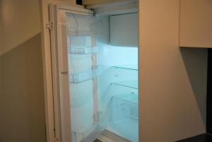 um frigorífico vazio com a porta aberta num quarto em Bungalows Bospark te Stramproy em Stramproy