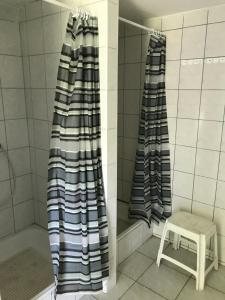 a bathroom with two shower curtains and a stool at Oliver Inn Camping in Balatonlelle