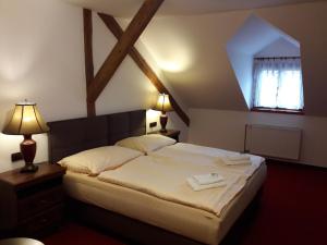 - une chambre avec un grand lit et une fenêtre dans l'établissement Hotel Fogl, à Nová Bystřice