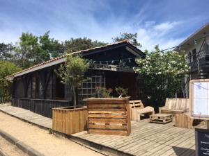 a house with a wooden deck with a building at Le Pavillon Bleu in Cap-Ferret