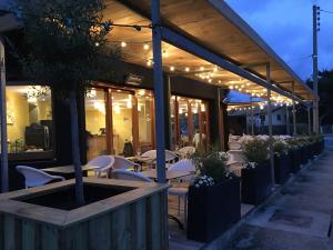 un ristorante con tavolo, sedie e luci di Le Pavillon Bleu a Cap-Ferret