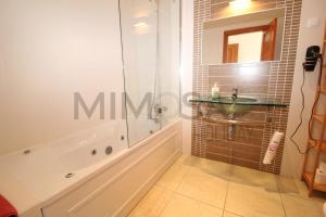 a bathroom with a tub and a sink and a mirror at Alba Mar in Lagos