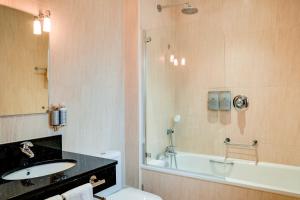 a bathroom with a sink and a toilet and a tub at Oakley Hall Hotel in Basingstoke +37 photos