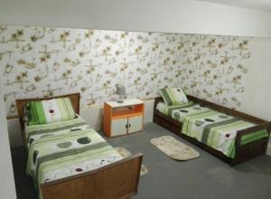 a bedroom with two beds and a wall with flowers at Solar de Paz in Rivera