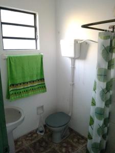 a bathroom with a toilet and a sink and a green towel at Solar de Paz in Rivera
