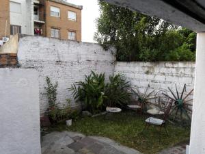 リベラにあるSolar de Pazのレンガの壁の隣に椅子と植物が置かれた庭
