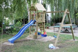 einen Holzspielplatz mit Rutsche und Rutsche in der Unterkunft Pension Gartner in Wallern im Burgenland