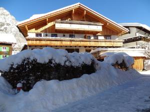ein schneebedecktes Haus davor in der Unterkunft Ferienwohnung am Eck in Bad Hindelang