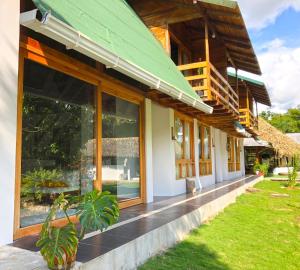 a house with large windows and a green roof at TAGUA LODGE in Tena
