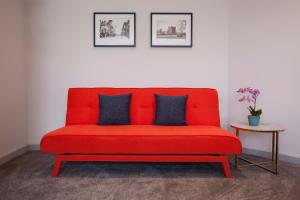 a red couch in a room with a table at Asperion Hotel in Guildford