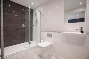 a bathroom with a toilet and a shower and a sink at Asperion Hotel in Guildford