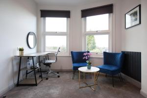 an office with two chairs and a desk and two windows at Asperion Hotel in Guildford